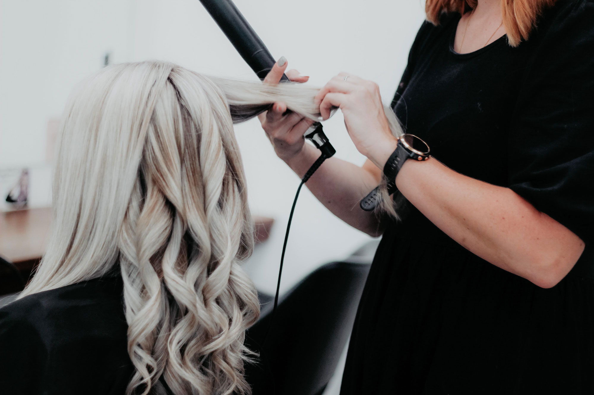 Hair Stylist doing the hair of the client in front of the mirror